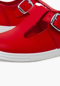 Scarpe in pelle rossa con design a punta chiusa, ritagli laterali e fibbia argentata. Suola in gomma bianca per maggiore aderenza e comfort.