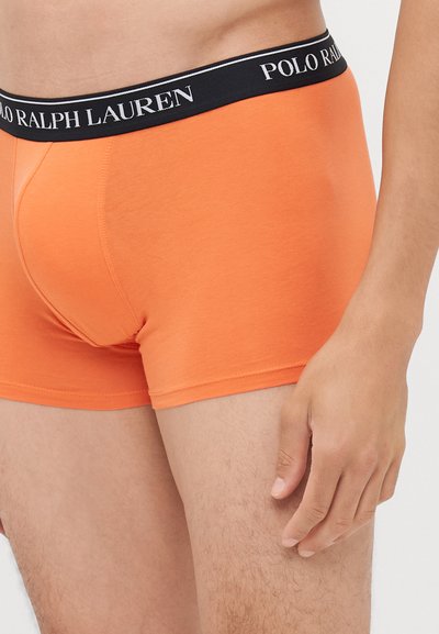 Boxer briefs arancioni in cotone con una fascia nera recante la scritta "POLO RALPH LAUREN" in lettere bianche; texture liscia e design aderente.