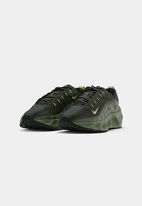 Zaļi un melni skriešanas apavi ar teksturētu virsu, caurspīdīgu starpsole un melnu gumijas zolēm. Iezīme - zelta Swoosh logo.