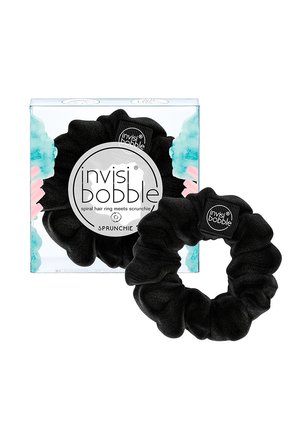 Zwarte Invisibobble scrunchie naast de doorzichtige doosverpakking met blauwe en roze accenten en zichtbaar merktekst.