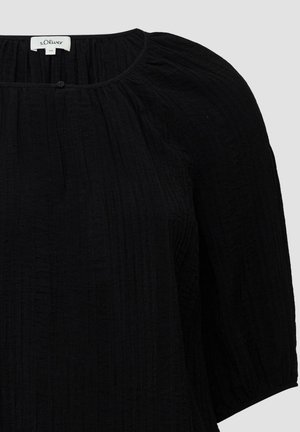 Blusa nera con tessuto testurizzato e stropicciato, colletto rotondo e maniche a tre quarti. Presenta un piccolo bottone al colletto.