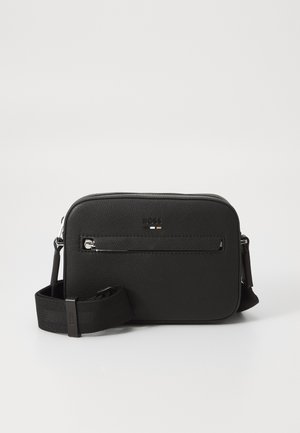 Bolsa crossbody retangular preta feita de material sintético texturizado. Apresenta um bolso frontal com fecho e uma alça ajustável. Design minimalista.