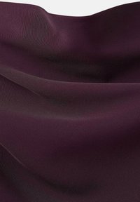 Tessuto di raso viola profondo e liscio con pieghe morbide e fluenti e una leggera lucentezza che riflette la luce.