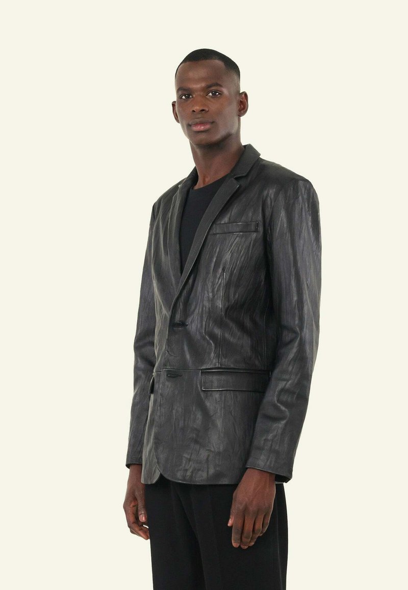 Zwart leren blazer met een gestructureerde afwerking, sluiting met één knop en gesneden revers, voorzien van twee voorzakken en een slim-fit ontwerp.