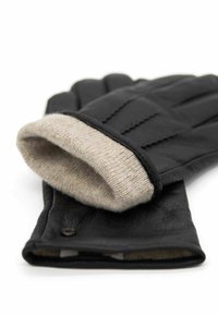 Schwarze Ledermittens mit einem beigen Strickfutter, versehen mit horizontalen Nahtdetails und einem Druckknopfverschluss am Bündchen.