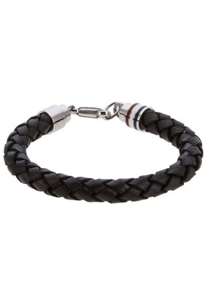 Bracelet en cuir noir tressé avec fermoir en argent et anneaux métalliques décoratifs avec des rayures rouge, blanc et bleu à une extrémité.