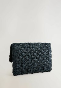 Tummansininen kudottu clutch, jossa on kukkakuosiset tekstuurit, suorakulmainen muoto ja läppäsulku. Valmistettu pehmeästä ja joustavasta materiaalista.
