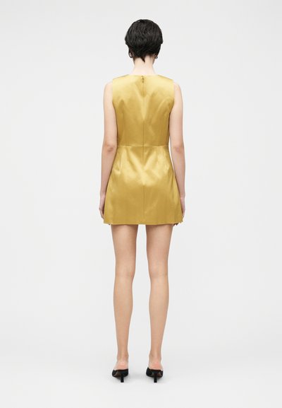 Vestido amarelo de cetim sem mangas, com corpete ajustado e saia evasê, com fecho de correr oculto nas costas e detalhes mínimos de costura.