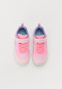 Baskets Skechers en rose et violet clair, avec un dessus en maille, des fermetures à lacets et à bride, ornées de motifs rayés horizontaux sur le côté.