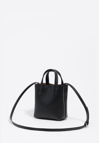 Mała czarna skórzana torebka z dwoma krótkimi uchwytami i długim regulowanym paskiem na ramię na białym tle.