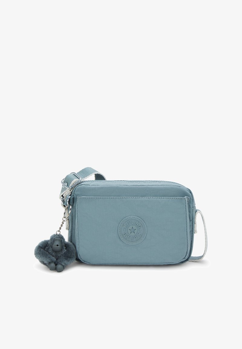 Blue nylon crossbody bag with a zip closure, textured surface, round logo patch, and a monkey keychain accessory for detail.