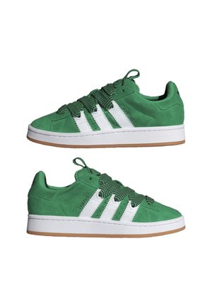 Green suede sneakers with white stripes, thick patterned laces, white midsoles, and gum-colored outsoles, shown in side views facing opposite directions.