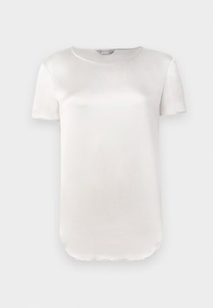 Kortermet, lys beige satengbluse med rund hals og buet nederkant, vist på ensfarget lys bakgrunn.