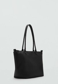 Svart tote-väska med två långa handtag, med en enkel, modern design mot en ljusgrå bakgrund.