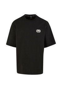 Black cotton t-shirt with short sleeves, round neck, and a white logo on the chest. Smooth texture, loose fit, and simple design.