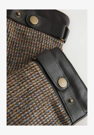 Barna gyapjúszövet kék és zöld pettyekkel, fekete bőr díszítéssel és réz patentokkal a biztonságos záródásért.