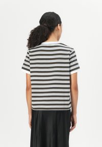 Stripet kortærmet skjorte med vandrette mørkebrune og hvide striber. Stoffet ser blødt ud med en afslappet pasform og rund halsudskæring.
