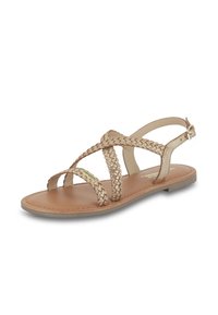 Sandales plates beiges avec un design de bride tressée métallisée et une fermeture à boucle à l'arrière, présentant une semelle lisse et un bout ouvert.