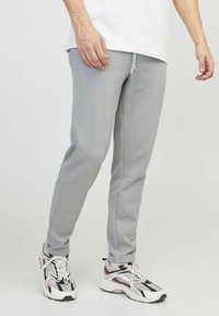Light gray sweatpants made of soft fabric, featuring a straight leg design, elastic waistband with drawstring, and ribbed cuffs.