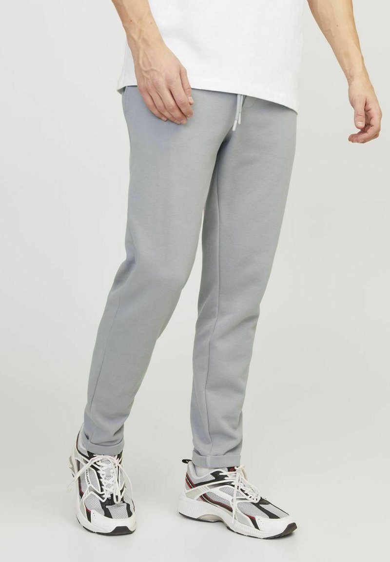 Light gray sweatpants made of soft fabric, featuring a straight leg design, elastic waistband with drawstring, and ribbed cuffs.