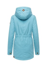 Jasnoniebieska wodoodporna kurtka z kapturem, elastycznym pasem i mankietami zapinanymi na napy. Na plecach, w pobliżu dekoltu, znajduje się brązowa łatka z logo.