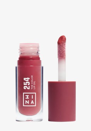 Huile à lèvres rouge dans un tube transparent étiqueté 254 avec un applicateur montrant une pointe de pinceau douce et inclinée couverte de produit.