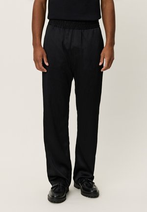 Melnas, krokotas bikses ar elastīgu jostasvietu un sānu kabatām. Izgatavotas no viegla auduma, ar brīvu piegriezumu un taisnām kājām.