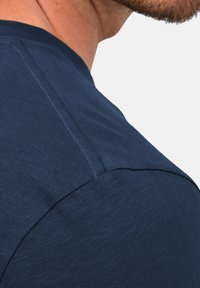 Granatowy t-shirt z krótkim rękawem wykonany z tkaniny o fakturze, z prostym wzorem, widocznymi szwami i luźnym krojem.