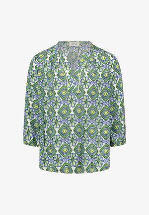 Blouse avec motifs géométriques et floraux verts, bleus et jaunes, manches 3/4, encolure en V avec passepoil blanc, coupe décontractée.