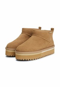 Botas de tobillo de ante en color marrón con un acabado texturizado, que cuentan con una suela de goma resistente, un perfil bajo y costuras decorativas.