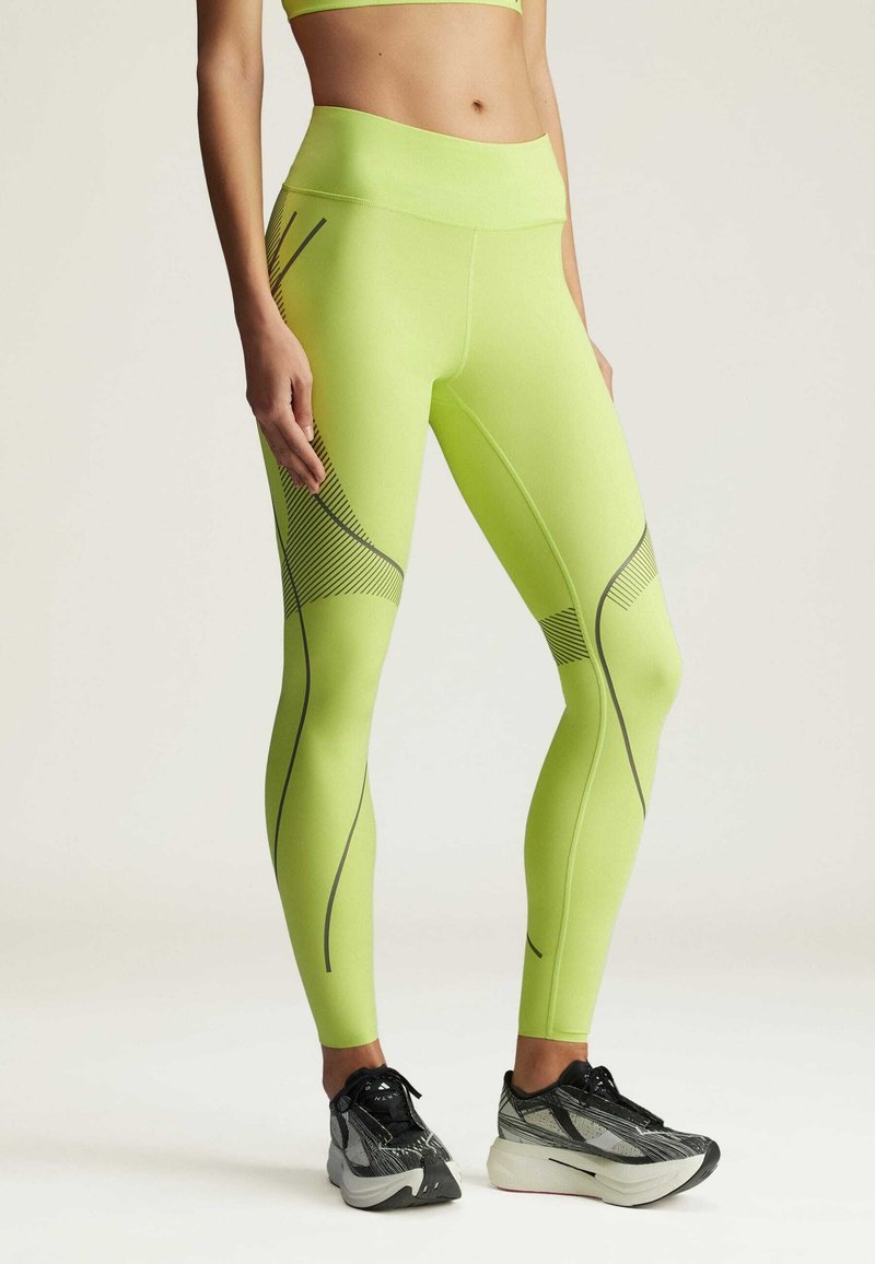 Neon green leggings with a high waistband, featuring diagonal black stripes and textured accents at the thigh. Stretchy fabric, athletic fit.