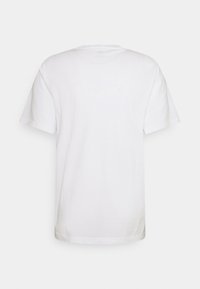 T-shirt blanc uni à manches courtes vu de dos avec un col rond sur un fond clair.