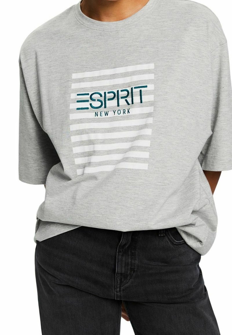 Grå oversized t-shirt med rund halsringning, med ett randigt mönster och "ESPRIT NEW YORK" logotyp i teal och svart broderi.