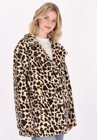 Leopardenmuster-Mantel aus weichem, plüschigem Material mit doppelter Knopfleiste, großem Kragen und Fronttaschen. Farben: beige, braun, schwarz.