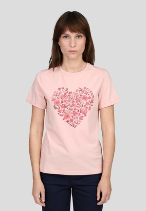 T-shirt en coton rose avec un cœur composé de motifs floraux dans des teintes de rose et de rouge. Encolure ronde, manches courtes et coupe standard.