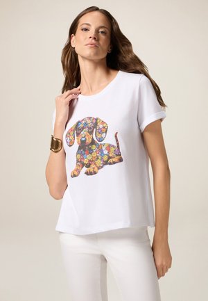 Witte katoenen T-shirt met een kleurrijk bloemenpatroon van een teckel. Korte mouwen en een relaxte pasvorm met een ronde hals.
