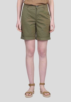 Shorts en coton vert olive, avec des ourlets roulés, cinq poches, fermeture à bouton à l'avant. Associés à des sandales beiges avec des brides chevillées.