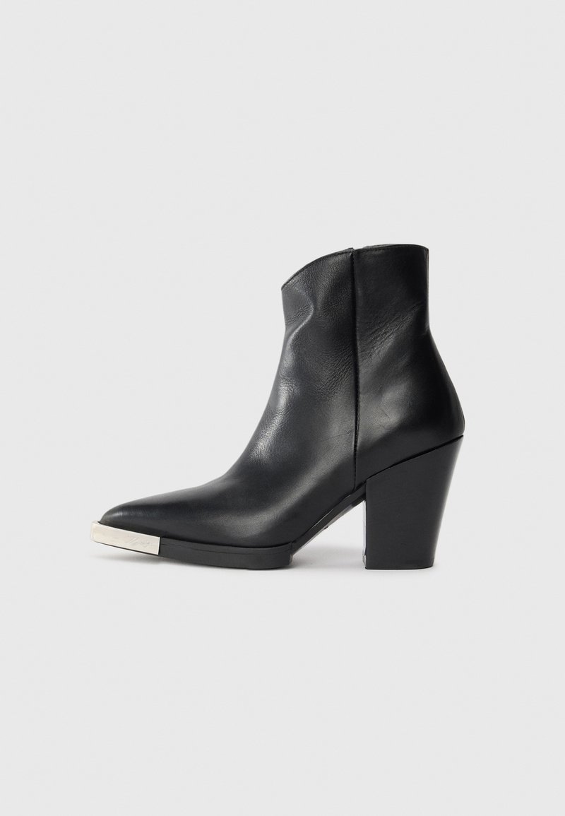 Must mustaankle saapad terava nina, kõrge plokknina ja hõbedane varbakattega detail. Sile tekstuur ja lihtne disain.
