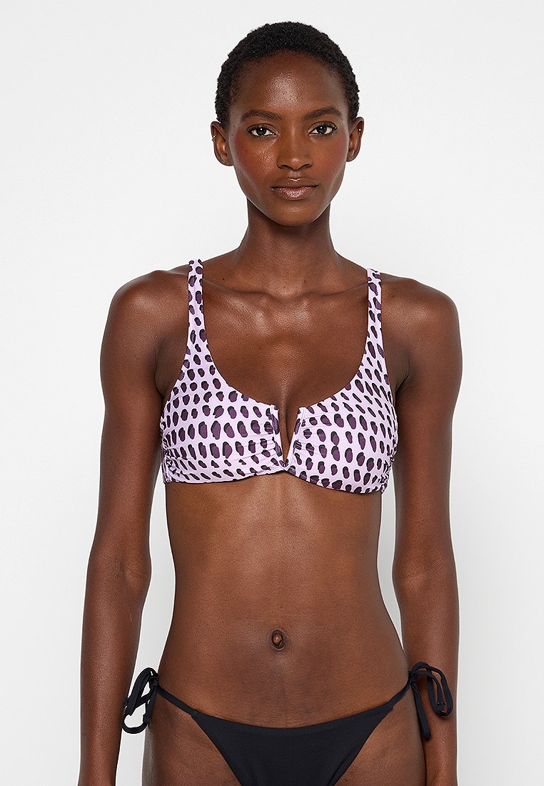 Lila gepunkteter Bikini-Oberteil mit tiefem V-Ausschnitt und verstellbaren Trägern; glatte Textur; kombiniert mit einem schwarzen Bikini-Unterteil mit Bindebändern.