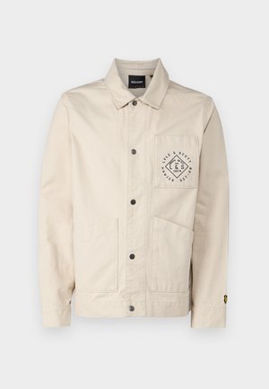 Giacca beige in cotone con colletto, tasche frontali e patch con logo sul petto. Caratterizzata da chiusura a bottoni e maniche lunghe.