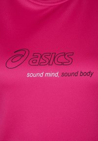 Růžové sportovní tričko vyrobené z texturované tkaniny, s logem značky 'asics' a textem "zdravá mysl, zdravé tělo" v černém tisku.