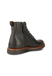 Bota de cuero negra hasta el tobillo con un acabado texturizado, diseñada con cierre de cremallera y cordones, montada sobre una suela contrastante en marrón y gris.
