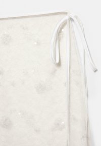 Przezroczysta biała tkanina z kwiatowymi wzorami i cekinami, wykończona na jednym boku białą wstążką do zawiązania. Delikatna tekstura i lekka konstrukcja.