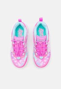 Rožiniai ir šviesiai mėlyni sportbačiai su blizgiu paviršiumi, turintys širdelės formos užsegimą, dekoratyvius akcentus ir spalvingą gradientinį raštą.