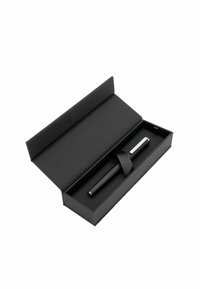 Caja de regalo negra que contiene un bolígrafo elegante con un agarre texturizado y acentos de cromo, asegurado con una cinta negra en su interior.