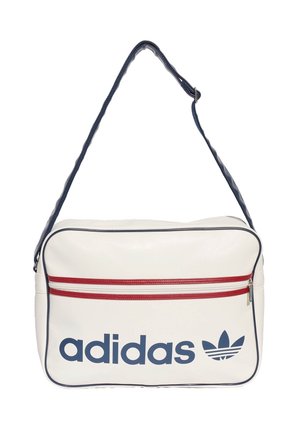 Bolso de hombro blanco de Adidas con ribete azul marino, bolsillo horizontal con cremallera roja y logo y texto de Adidas azul marino en el frente.