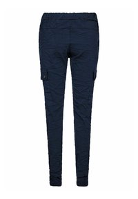 Tmavomodré nohavice z pokrčeného materiálu s elastickým pásom a bočnými cargo vreckami, s kužeľovito tvarovanými nohavicami a minimálnymi kovovými doplnkami.