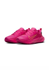 Zapatillas deportivas de un brillante color rosa con una parte superior de tejido texturizado, detalles en dorado, puntera redondeada, talón reforzado y sistema de cordones para un ajuste seguro.