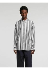 Sort-hvitt stripet langermet skjorte med krage, knappefester, venstre brystlomme og kontrasterende stripete mansjetter.