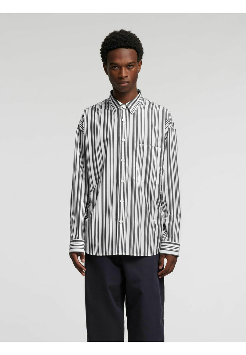 Sort-hvitt stripet langermet skjorte med krage, knappefester, venstre brystlomme og kontrasterende stripete mansjetter.